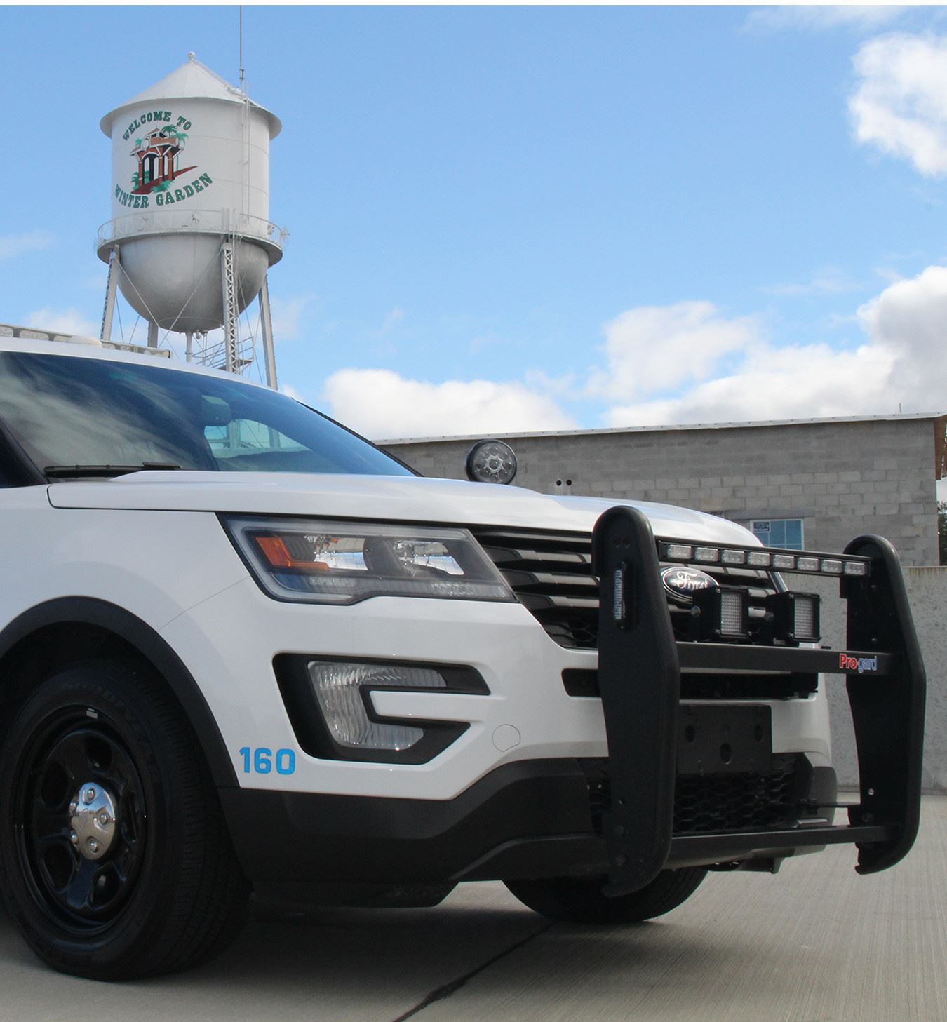 Police Vehicle Parked in Front of Water Tower